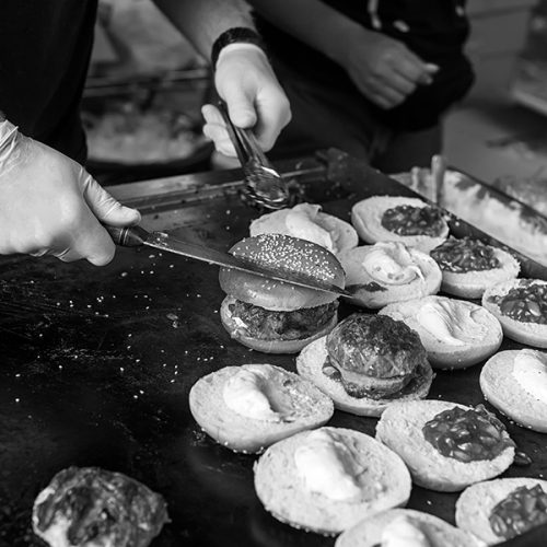 Grill cook preparing burgers at outdoor event