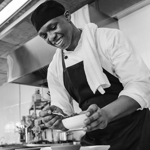 Kitchen assistant preparing main course for an event