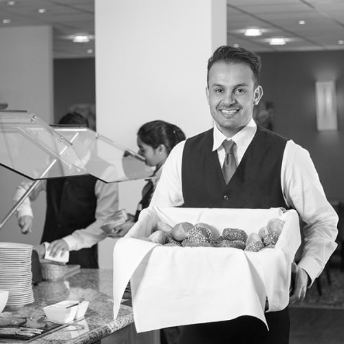 Buffet attendants working at buffet station.