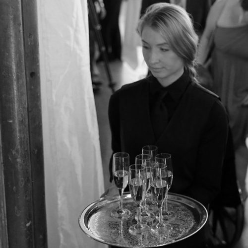 Hostess serving cocktails at an event.